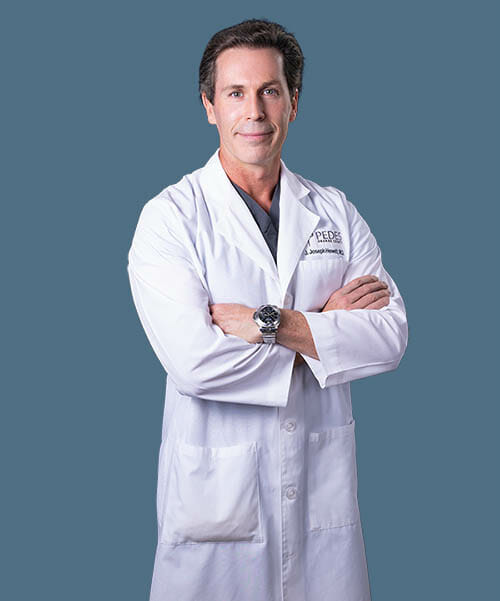 Joseph Hewett, M.D., Vascular Specialist at Pedes Orange County, in a lab coat.